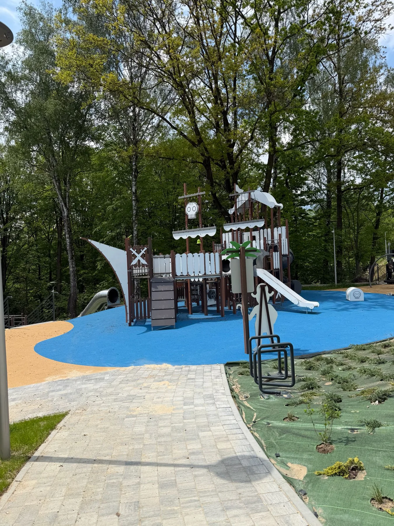 Laguna Beskidów — dětské hřiště s prolézačkou ve tvaru lodi a skluzavkami mezi stromy